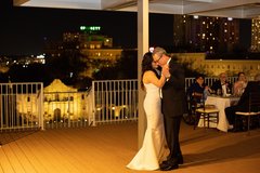 Bridge and groom dancing on rooftop overlooking Alamo Plaza