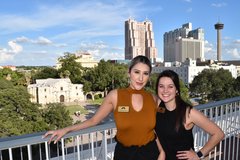 Two women at La vista Terrace with the Alamo and skyline in the background