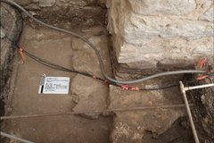 Irrigation line and ferrous pipe at bottom of excavation unit with a limestone feature