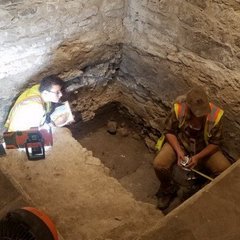 Archaeologists inside excavation unit