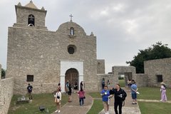 A group of guests walking outside the ground of a mission
