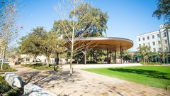 Pavilion stage in an outdoor area with large grassy area in front of the stage