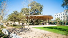 Pavilion stage in an outdoor area with large grassy area in front of the stage