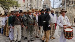 Living historians entering Alamo Plaza dressed as soldiers from Gonzalez