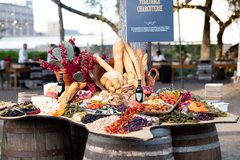 Vegetable charcuterie on a Texas shaped board placed on top of wine barrels