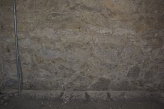 Limestone wall loss accumulating on black paper inside the Baptismal.