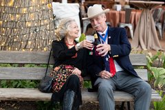 Woman and man sitting on a bench toasting each other at an event