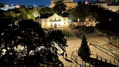 Alamo Church illuminated at night with a Christmas tree in the plaza