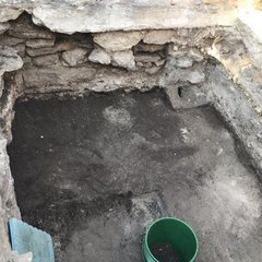 Archaeologists inside excavation unit