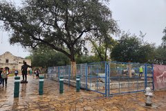 Blue fencing around excavation area in Alamo Plaza