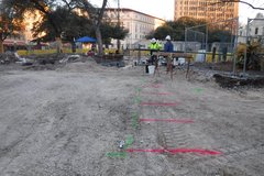 Dirt are with pink line on the left side of Alamo Plaza