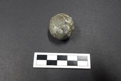 Musket ball next to a ruler for size