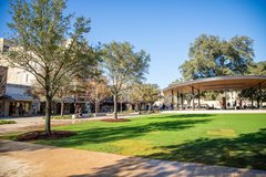 Covered pavilion stage in front of large grass area in community park