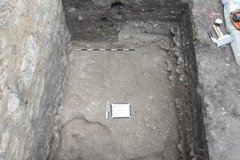 White board inside an excavation unit with a rock inlay border