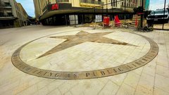 Tiles in the shape of a star inside a circle outside the H&m store