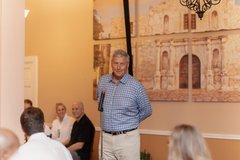 Man speaking at the microphone inside Alamo Hall