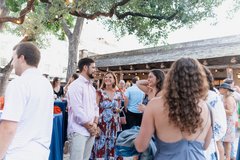 Guests laughing over cocktails in Alamo Hall Patio