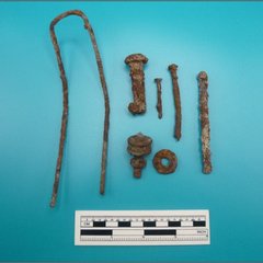 Ferrous metal wire, fasteners, and nails next a ruler for size