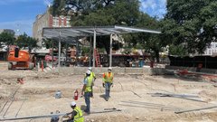 Construction area with stage pillars in development and construction workers on the ground