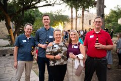 Five guests smiling at an event in Alamo Gardens