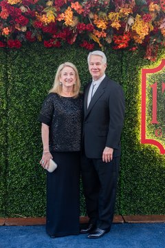 Woman in all black formal attire next to a man wearing a tuxedo with a bolo