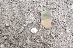 Piece of clay, button, and circular clasp like object found in excavation unit