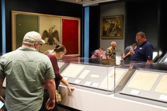 Visitors looking at documents inside of a clear case