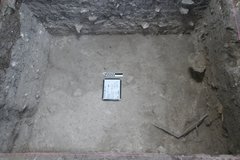 White board and marker on the dirt floor of an excavation unit