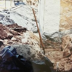 Plastic lining covering an excavation area on exterior of south wall