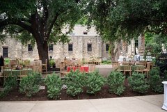 Round tables set up for event under trees in the Alamo Gardens