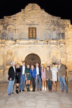 A group of men and women standing in front of Alamo Church