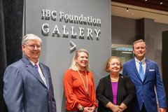 Two men and two women standing in front of IBC Foundation Gallery sign