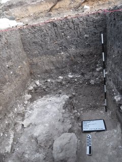 Inside of an excavation until with a white board and marker at the bottom