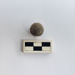 Musket ball next to a ruler for size