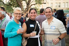 Three guests smiling at an event in Alamo Gardens