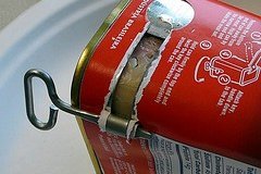 Metal key opening a can of food