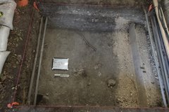 Excavation unit with a white board in the middle and a ruler for size
