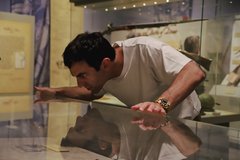 Man looking closely at a ring in a display case in the Alamo Exhibit