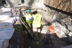 Two archaeologists standing in an excavation unit
