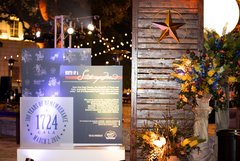 Columns and blue and yellow floral arrangements in front of a wooden wall with a star