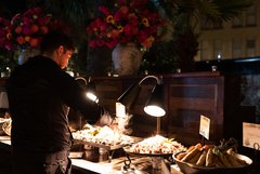 Server checking on meat at food station in Alamo Hall Patio
