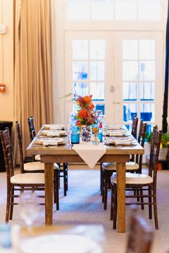 Long table set up in Alamo Hall with colorful flowers