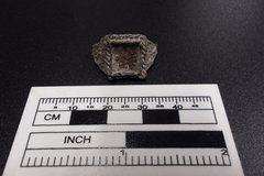 Ring with a square center next to a ruler for size