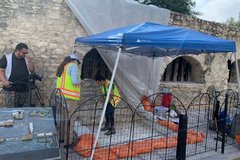 Blue pop up tent outside of Long Barrack lined with orange sandbags