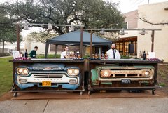Two bars made from the front of trucks placed at an outdoor garden event