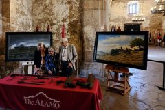 Kate Rogers and Louise and Donald Yena standing in Alamo Church looking at artifacts