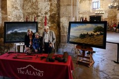 Kate Rogers and Louise and Donald Yena standing in Alamo Church looking at artifacts