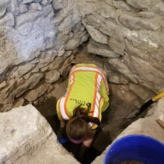 Archaeologist inside a small excavation unit