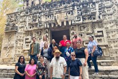 Group of educators in front of a wall sculpture in Mexico City