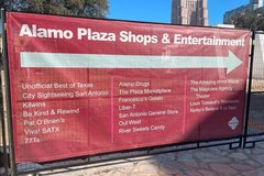 Red banner with arrow to show direction of Alamo Plaza Shops and Restaurants